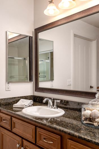 a bathroom with a sink and a mirror at Le Blanc Apartment Homes, Canoga Park, CA